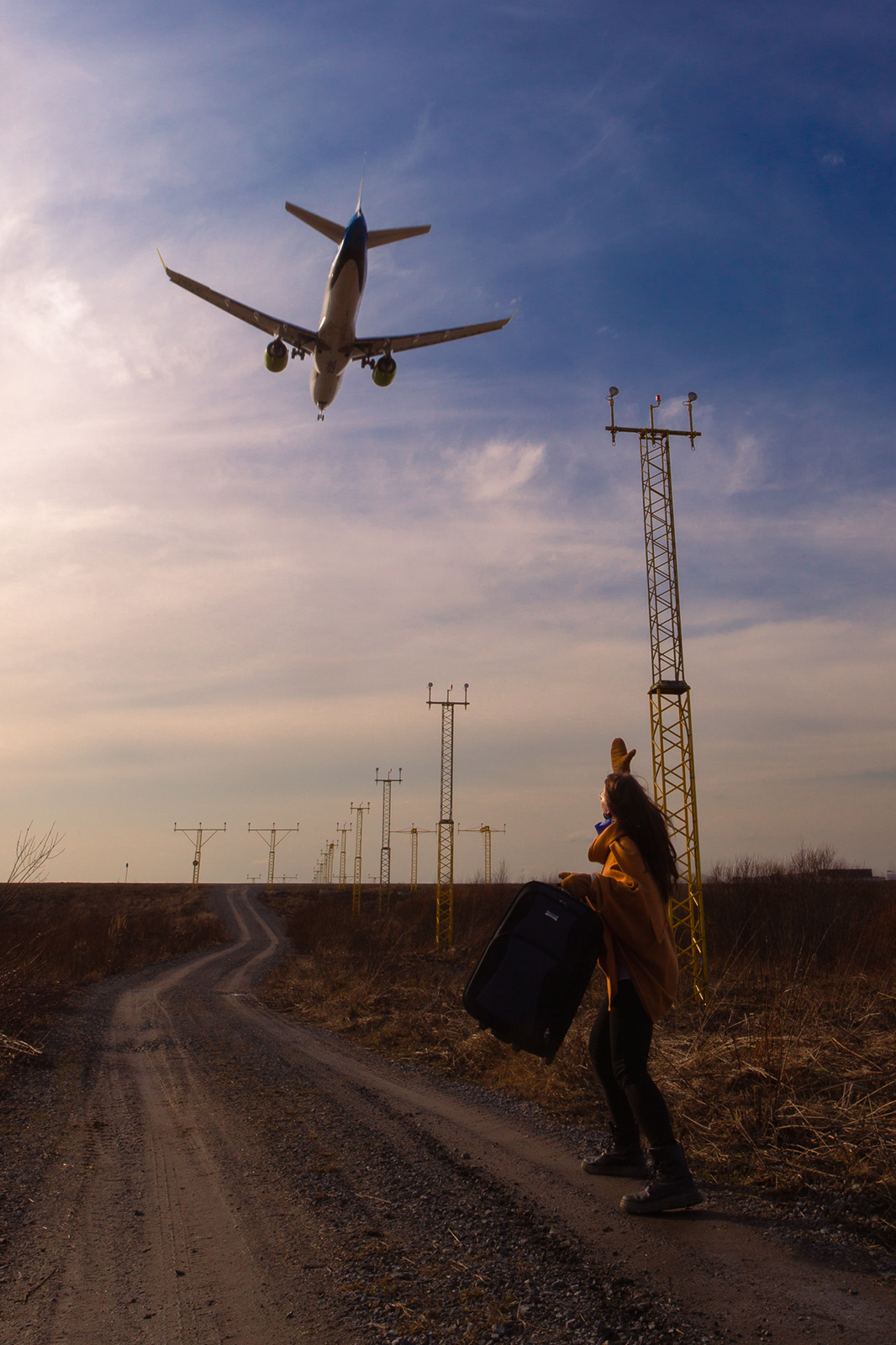 Commercial and promotional photography of a plane flying over Tampere at sunset, with a left-behind passenger waving from below.